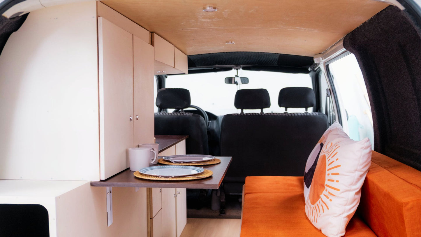 Two steel triangle angle brackets mounting a 90° wooden joint in a campervan cabinet, showing screw holes for secure installation
