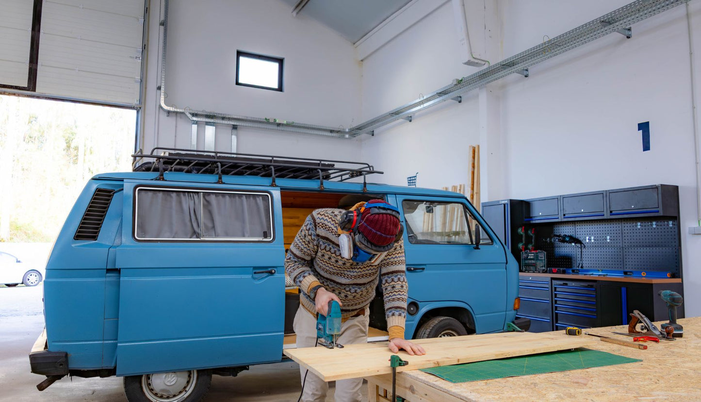 Spacious van conversion workshop in Porto with workbenches, power tools, and storage shelves
