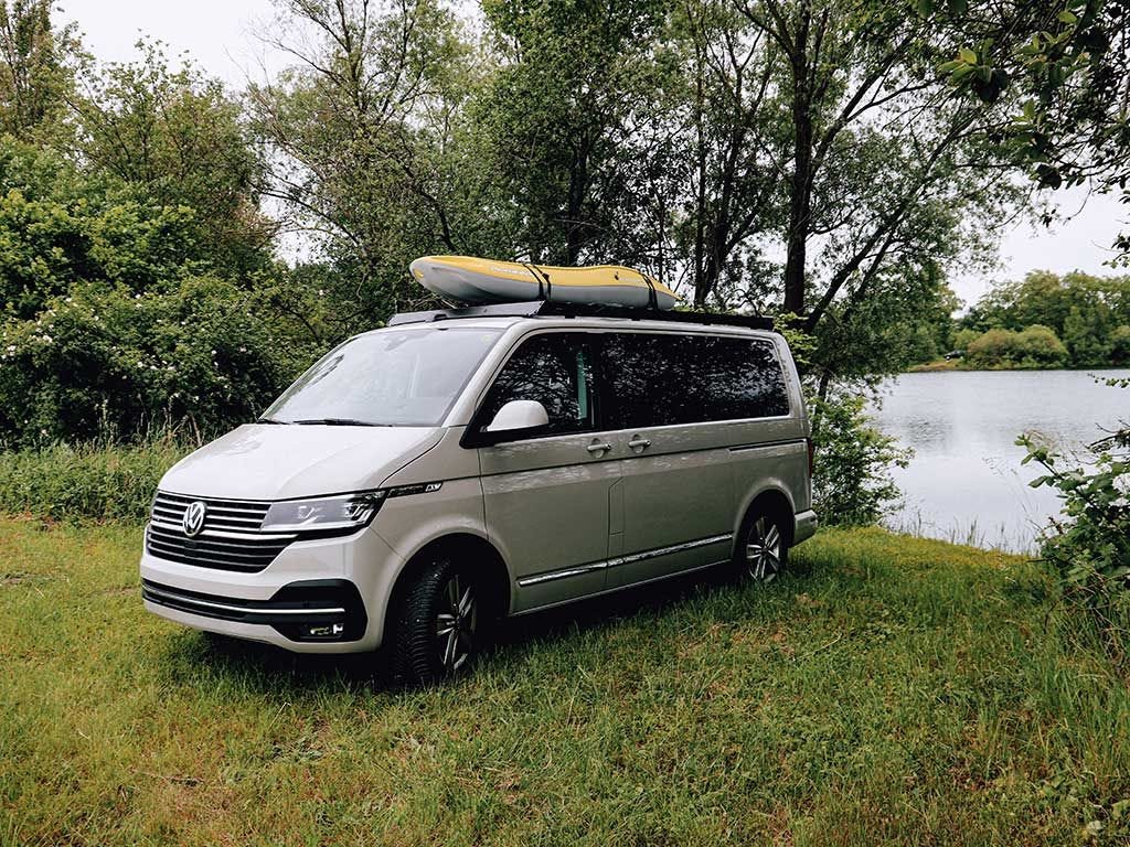 Volkswagen T6.1 Transporter driving with Slimsport roof rack, showcasing quiet aerodynamic design.