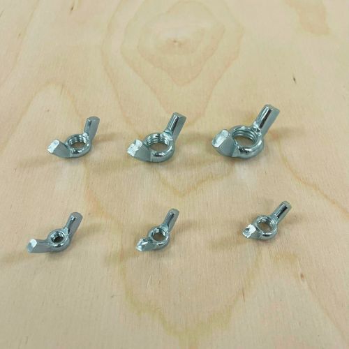 Set of corrosion-resistant steel wing nuts on workshop surface